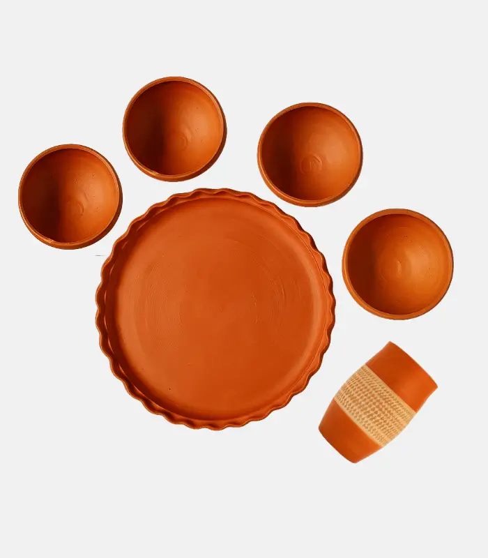 traditional clay thali with bowls and glass